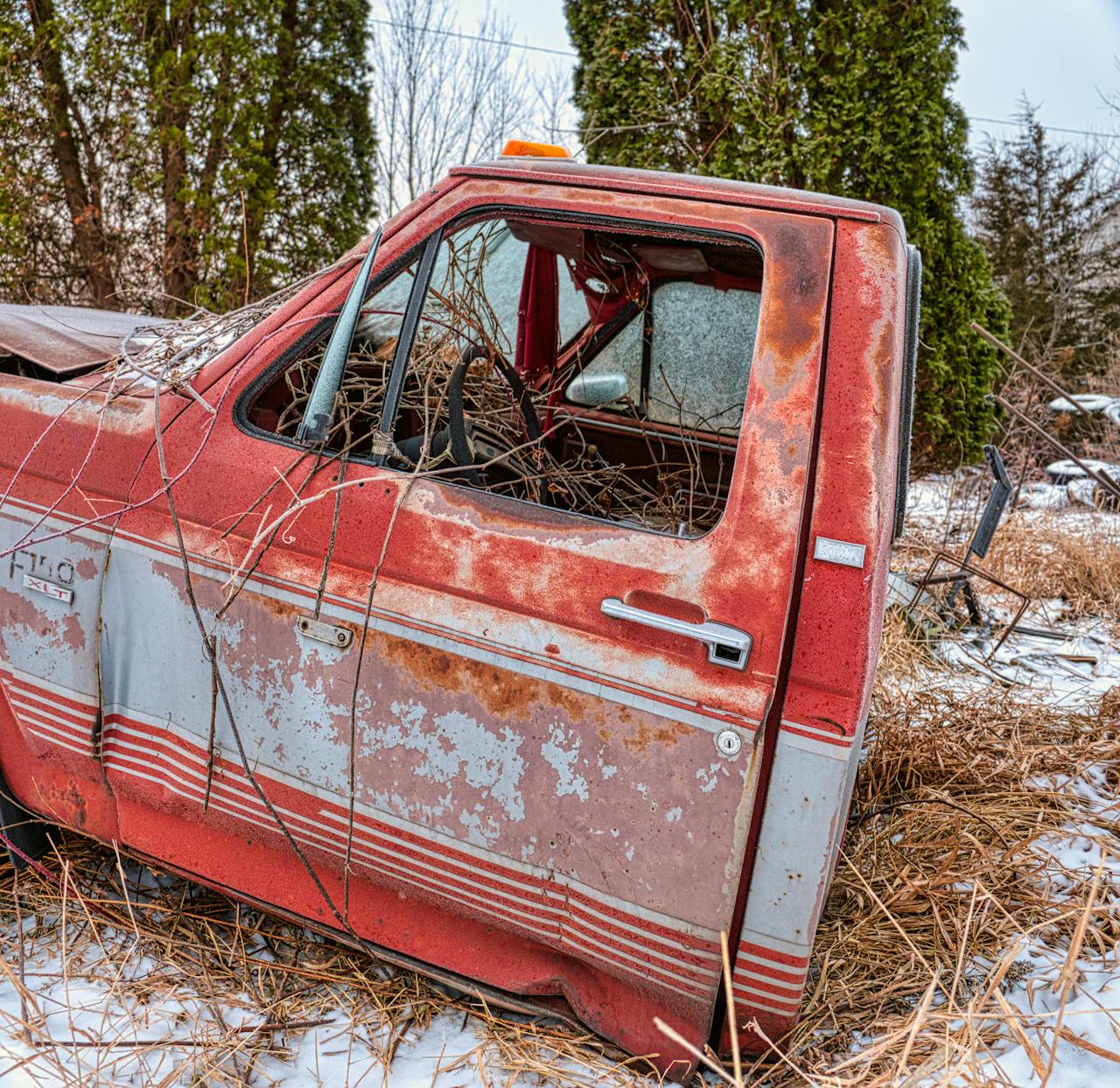 Junk Car Front of Red Pick Up Truck on Brown Grass